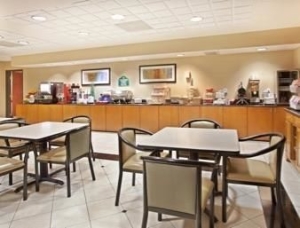 the breakfast area with tables chairs and small breakfast spread available at the wingate arlington tx