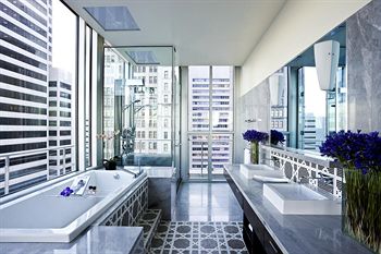 Beautiful modern corner bathroom with tile floors and deep soaking tub at The Joule in Dallas Texas