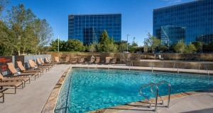 beauitful outdoor pool with tables and chairs at the Granite Park Hilton in Plano Tx