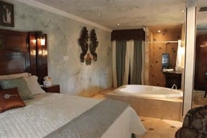 this guestroom features a heart shaped jacuzzi tub and king bed at the lockheart gables b&b in fort worth texas