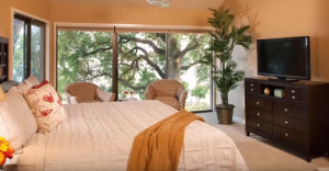 guestroom with king bed with a beautiful wooded view at the inn on lake granbury in texas