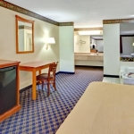 this suite includes a king bed along with ho tub and work desk at the super 8 motel arlington tx sw