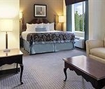 suite with king bed sitting area and jacuzzi in the bathroom at the arlington tx wyndham wingate