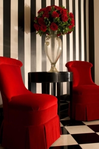 2 bright cherry red chairs with black stripped wall paper inside the lobby of the le meridien stoneleigh