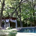 the outdoor wedding ceremony venue from afar right beside the pool at the wildwood inn denton tx