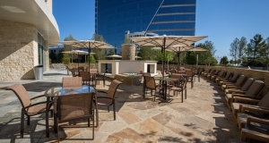 Beautiful Taupe outdoor patio with tables chairs and umbrellasat th Hilton Granite Park