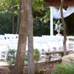 the outdoor wedding ceremony venue with white chairs at the wildwood inn denton tx