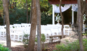 the outdoor wedding ceremony venue with white chairs at the wildwood inn denton tx