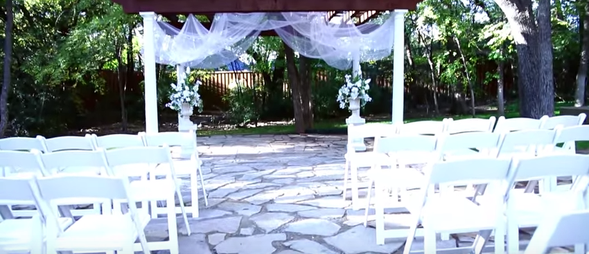 up close view of a wedding ceremony and white chairs at the wildwood inn denton tx