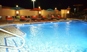 the outdoor pool at the blue cypress in arlington is well lit at night