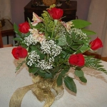 a bouquet of bright red roses sitting on a wedding reception table at the lockheart gables bed and breakfast