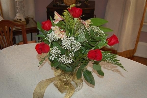 a bouquet of bright red roses sitting on a wedding reception table at the lockheart gables bed and breakfast